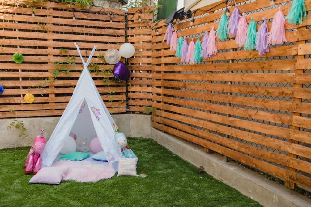 pexels photo 8384960 Charming children's party setup with colorful decorations and a tent in a garden setting.